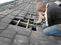 Roofer in Blackpool repairing slates on a roof